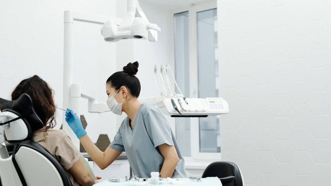 Dentista atendiendo a una paciente en una clínica dental