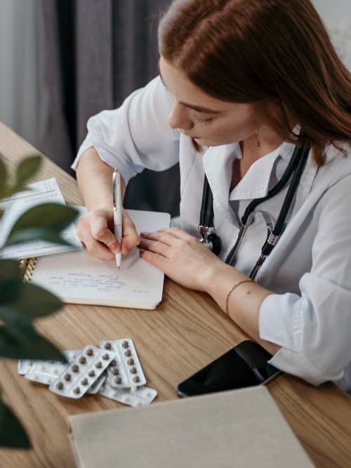 Médica tomando notas en su consulta