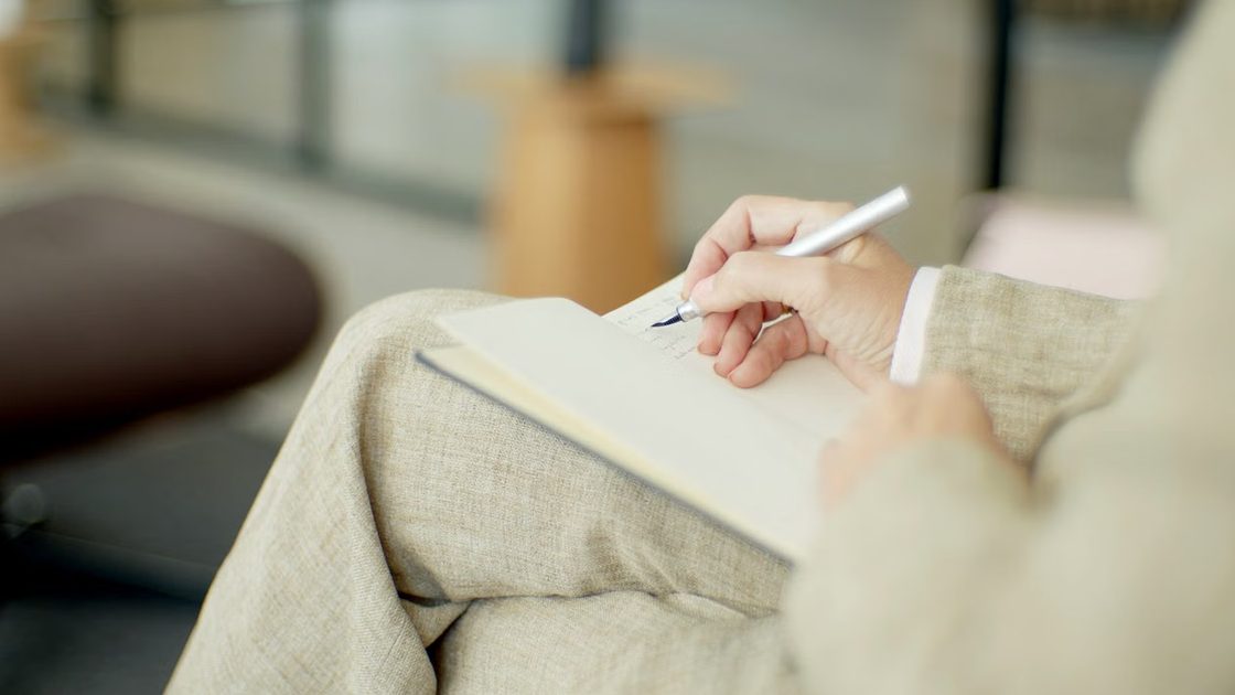 Psicóloga tomando notas en una libreta durante una sesión